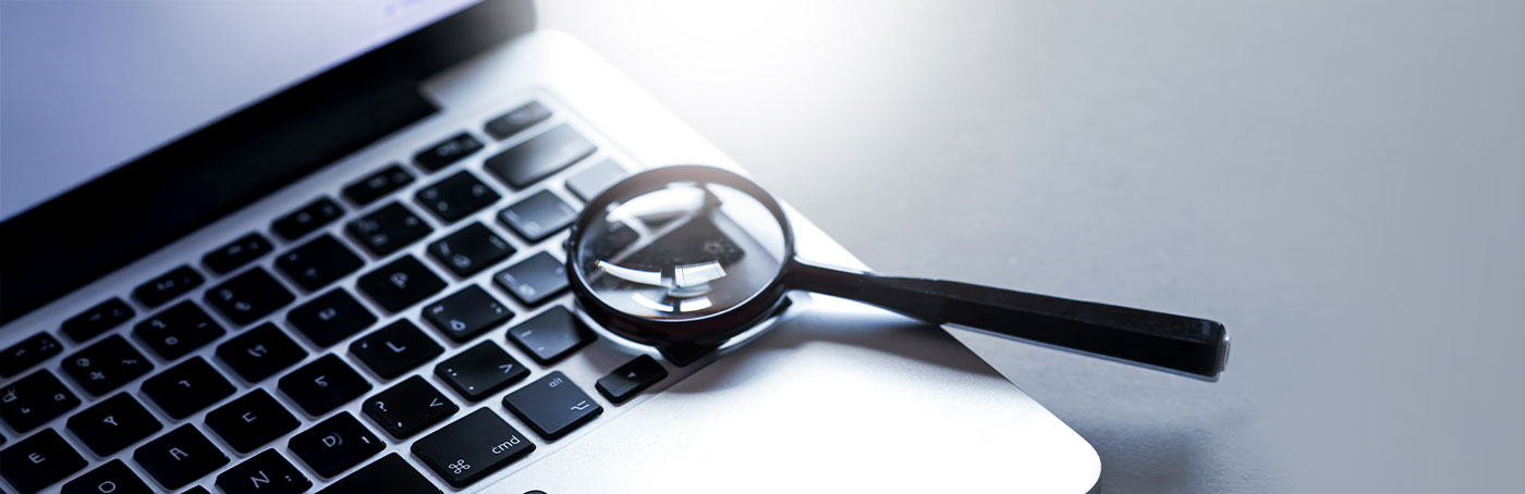 magnifying glass above a laptop keyboard